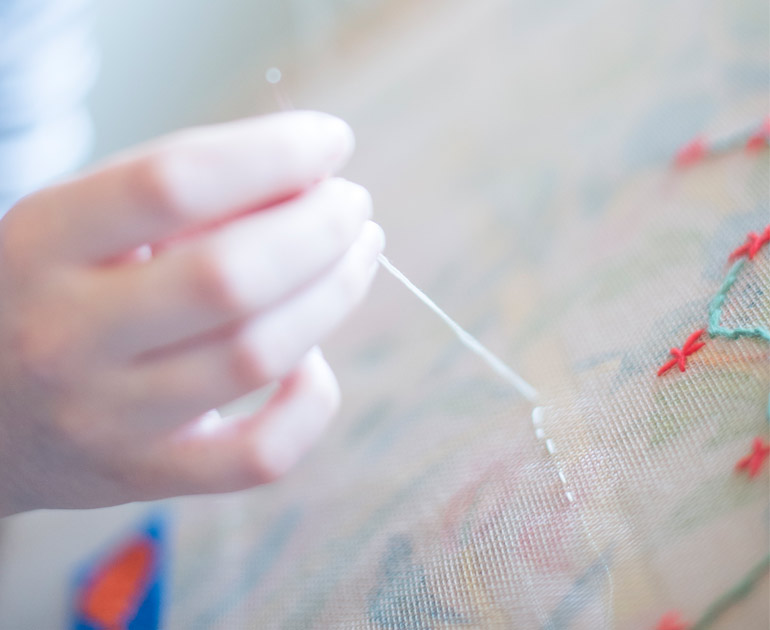 An image of a volunteer sewing as part of the Museum's Sew Engaging community project.
