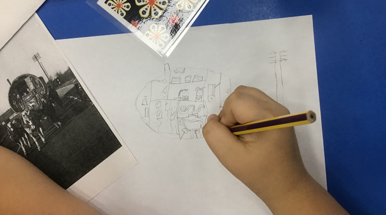 Child drawing from a picture of a vardo in pencil