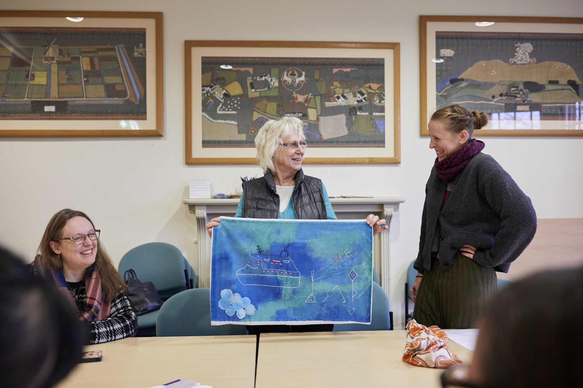 A member of the All Roads project holds up a textile they brought with them to Reading.