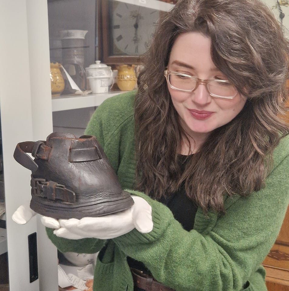 Jo Clement (a woman with long brown hair and glasses) holds an object at The MERL